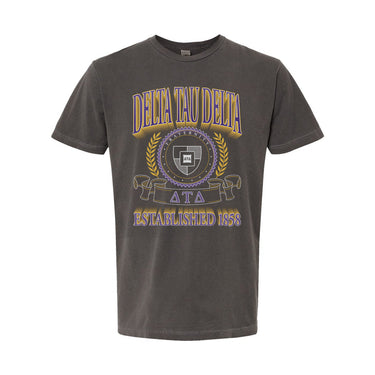 College-aged male wearing the fraternity Collegiate Crest Graphic Tee in charcoal grey, featuring vintage Delta Tau Delta crest artwork on campus.
