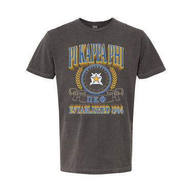 College-aged male wearing the fraternity Collegiate Crest Graphic Tee in charcoal grey, featuring vintage Pi Kappa Phi crest artwork on campus.