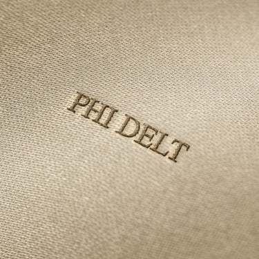 Soft beige fabric close-up showing a smooth, heavyweight knit texture with gentle folds and subtle draping.