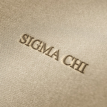 Soft beige fabric close-up showing a smooth, heavyweight knit texture with gentle folds and subtle draping.