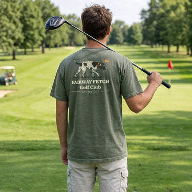 Man wearing a moss green Comfort Colors T-shirt with golf-themed graphic on the back.