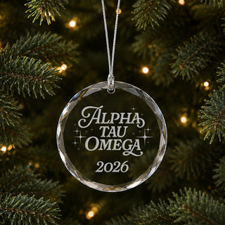 Limited Edition glass Christmas ornament with engraved design hanging on a decorated holiday tree