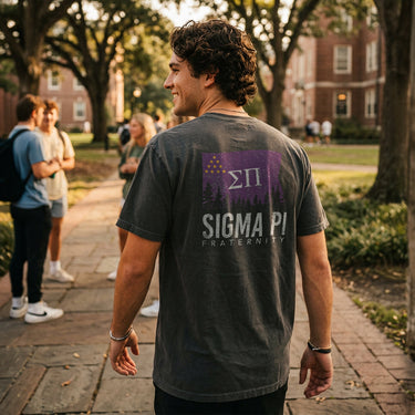 College student wearing fraternity grey t-shirt with colorful flag design on back