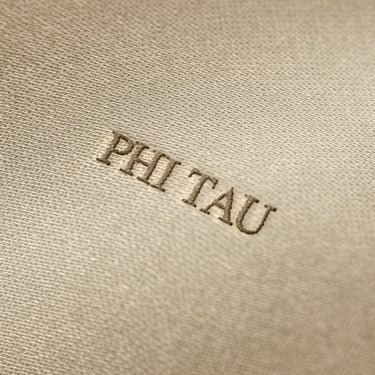 Soft beige fabric close-up showing a smooth, heavyweight knit texture with gentle folds and subtle draping.
