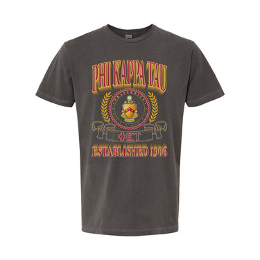 College-aged male wearing the fraternity Collegiate Crest Graphic Tee in charcoal grey, featuring vintage Phi Kappa Tau crest artwork on campus.