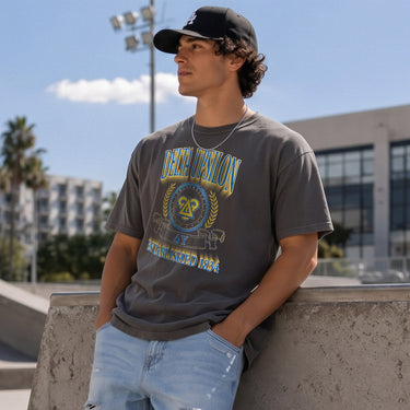 DU Collegiate Crest Graphic Tee in charcoal grey featuring bold Delta Uspilon lettering, fraternity crest, Greek letters, and established year design.