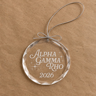 2026 Limited Edition clear glass holiday ornament featuring engraved fraternity design and silver hanging string