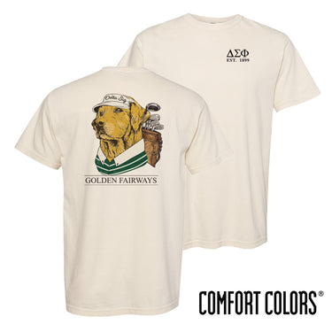 Golf-themed fraternity t-shirt on ivory Comfort Colors tee featuring a golden retriever wearing a golf hat and striped polo with golf clubs on the back. Perfect for fraternity golf events, rush, and casual campus wear.